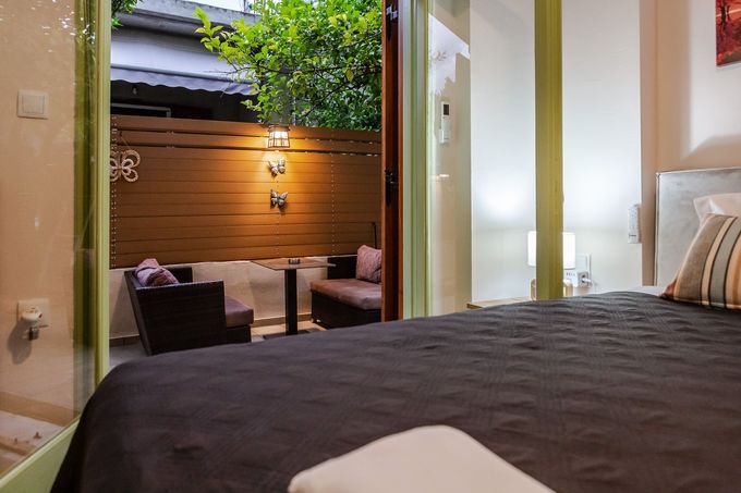 Bedroom opening onto a small private patio with seating and a wooden fence