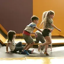 A group of children are playing on a trampoline.