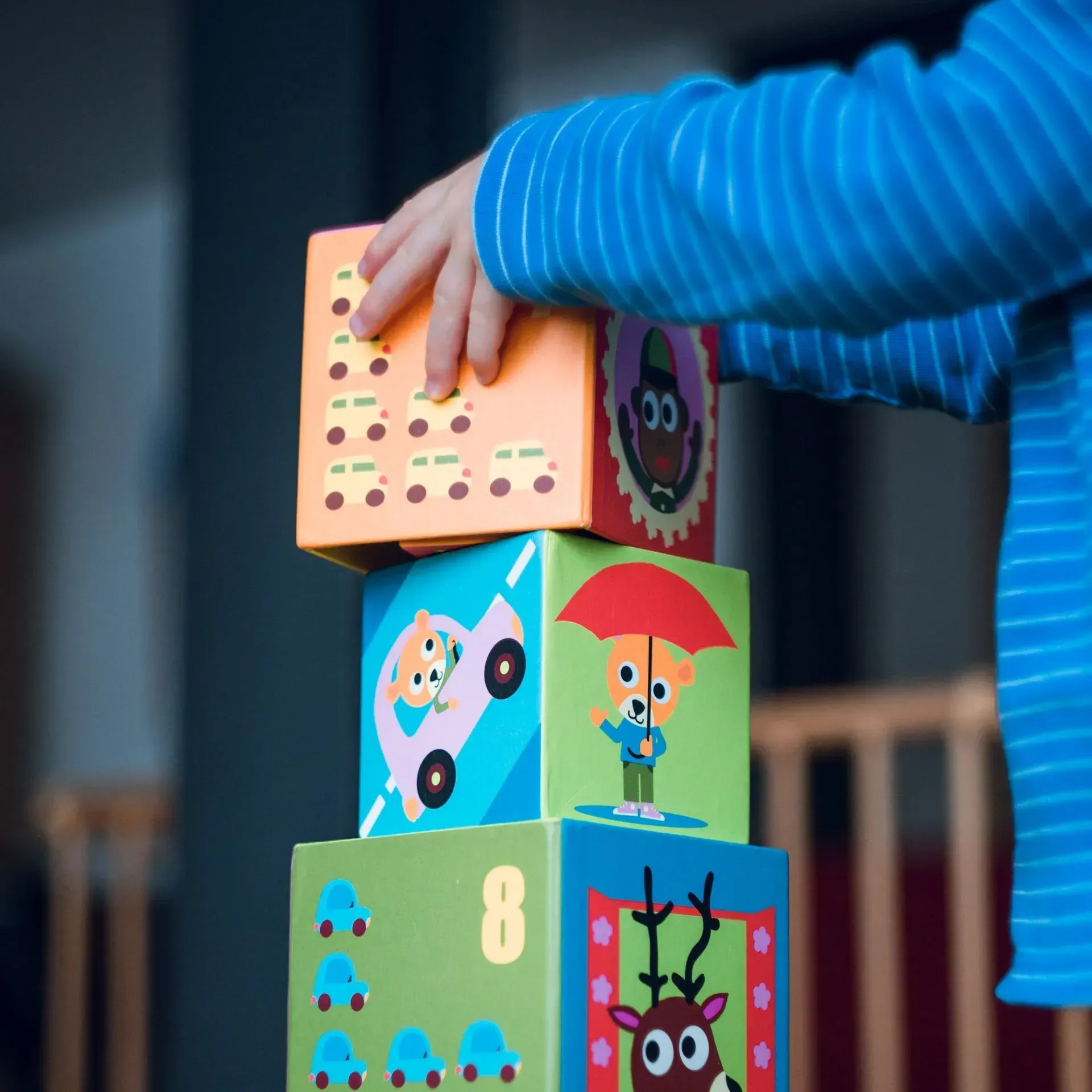 A child is stacking colorful blocks on top of each other.