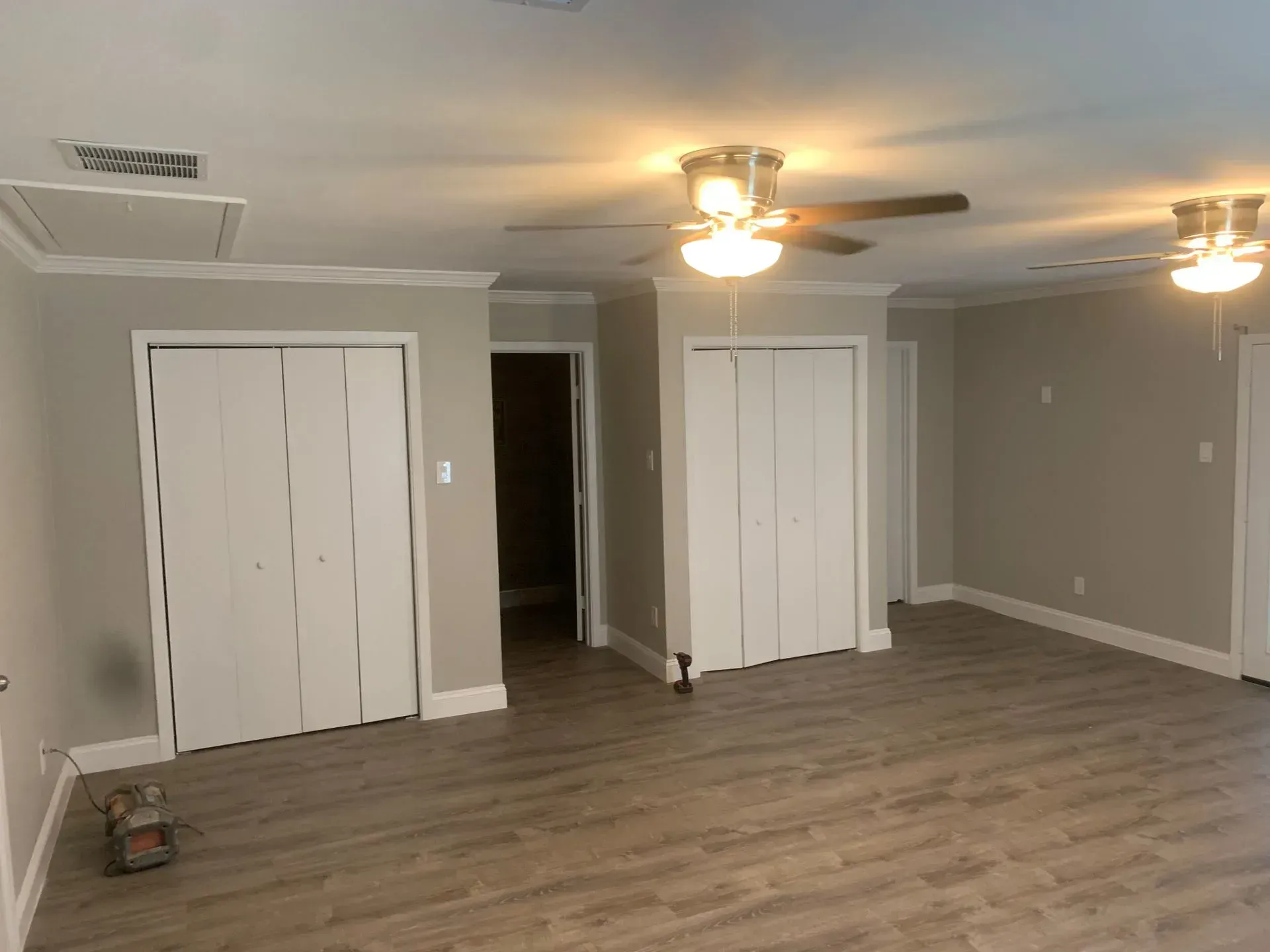 Empty room with gray walls, white trim, and two white closet doors.