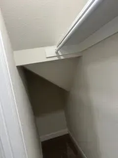 Small closet interior with a sloped back wall, painted white.