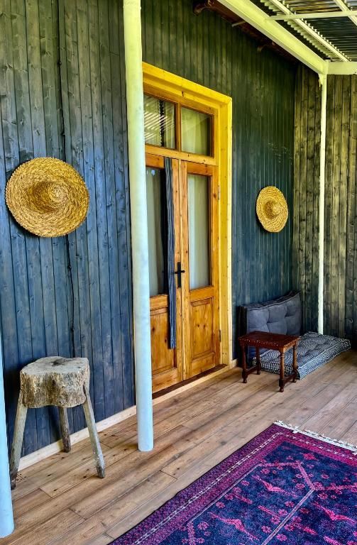 A porch with a wooden door and straw hats on the wall on a private terrace with Black sea views. Shromantic Garden.
