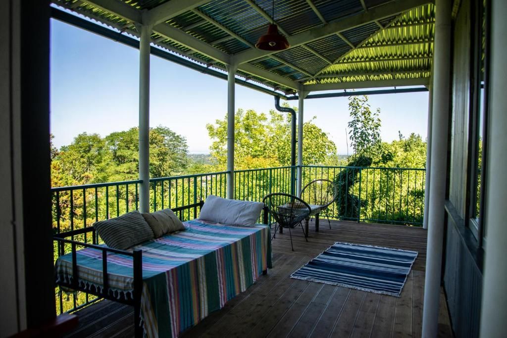 A porch with a bed and a rug on it on a private terrace overlooking the Black sea in a distance, Shromantic Garden, Guria