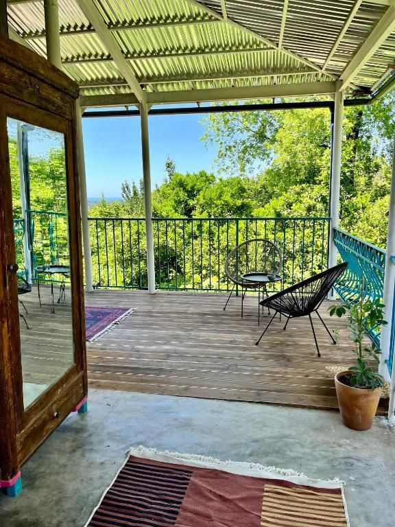 A private terrace in Shromantic Garden with wooden deck with chairs , a table and a mirror withe a view to Black Sea.