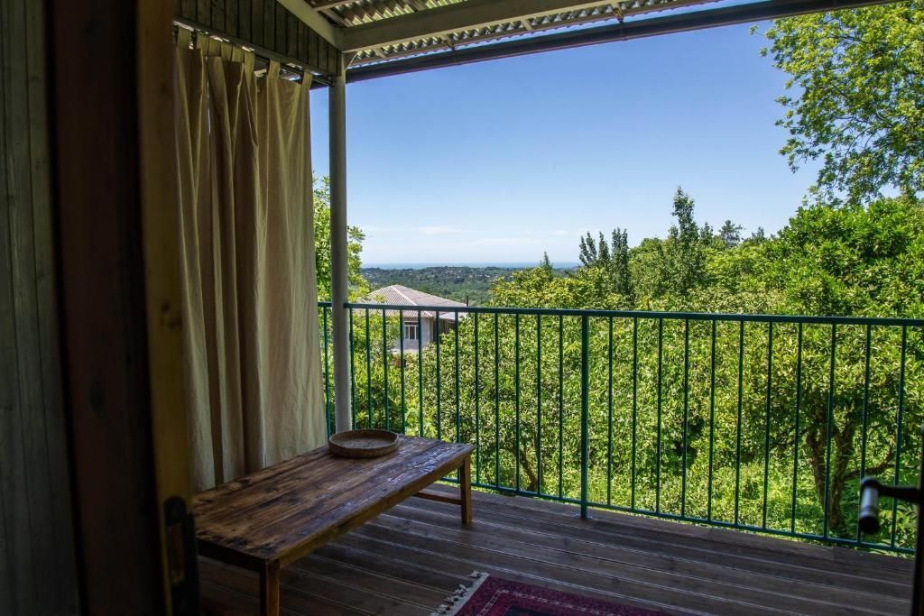 A private balcony with a view of trees and a blue sky and Black Sea in Shromantic Garden.