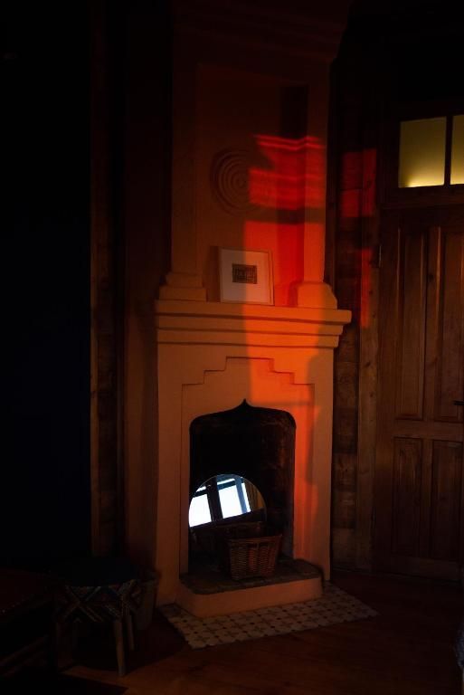 A fireplace is lit up in a dark room in Shromantic Garden.