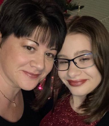 Two women wearing glasses are posing for a picture together