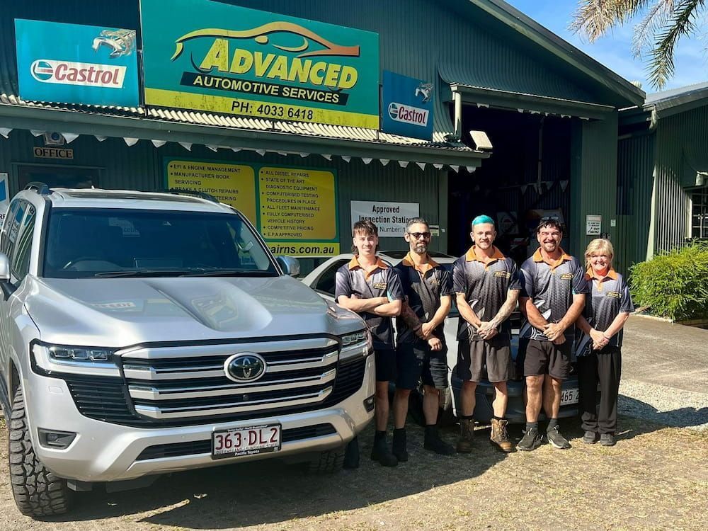 A Group Of People Standing In Front Of A Car In Front Of A Car Dealership — Advanced Automotive Services In Earlville, QLD