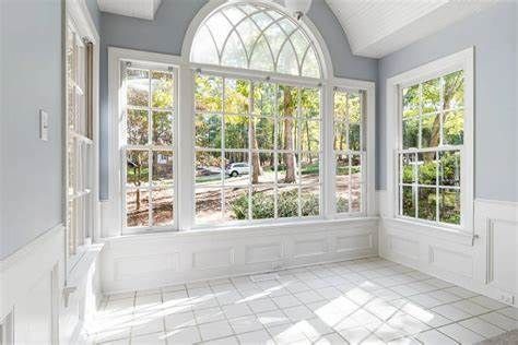 Sunroom with large windows, white trim, and a view of trees.