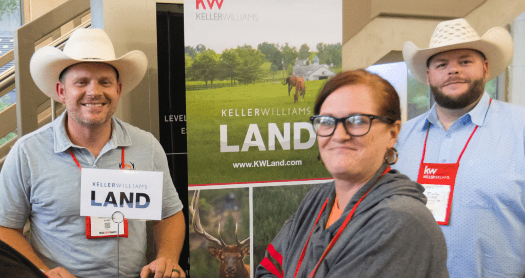 A group of people are standing in front of a sign that says land.