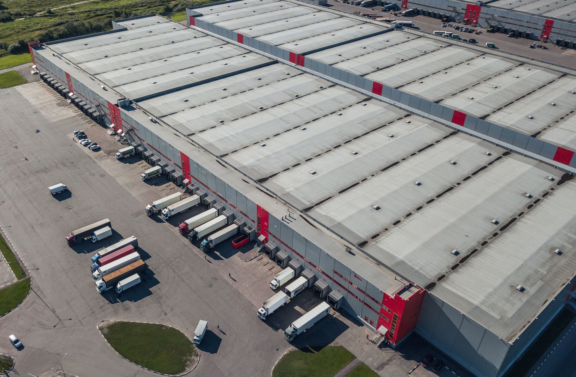 An aerial view of a large warehouse with trucks parked in front of it.