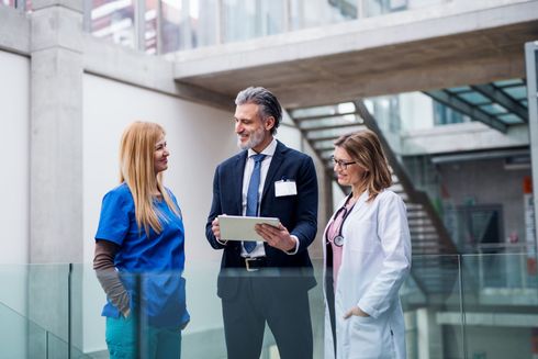 A group of doctors and nurses are standing next to each other in a hospital.