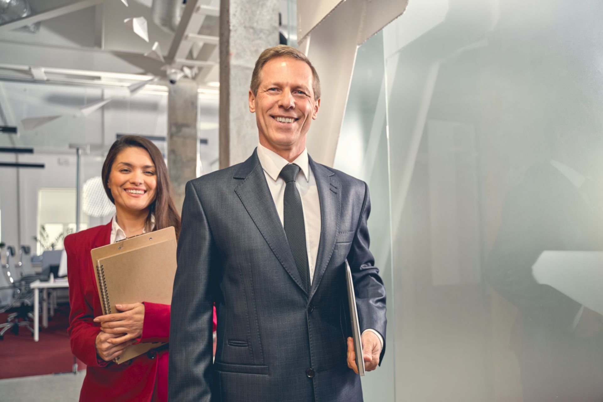 A man and a woman are standing next to each other in an office.
