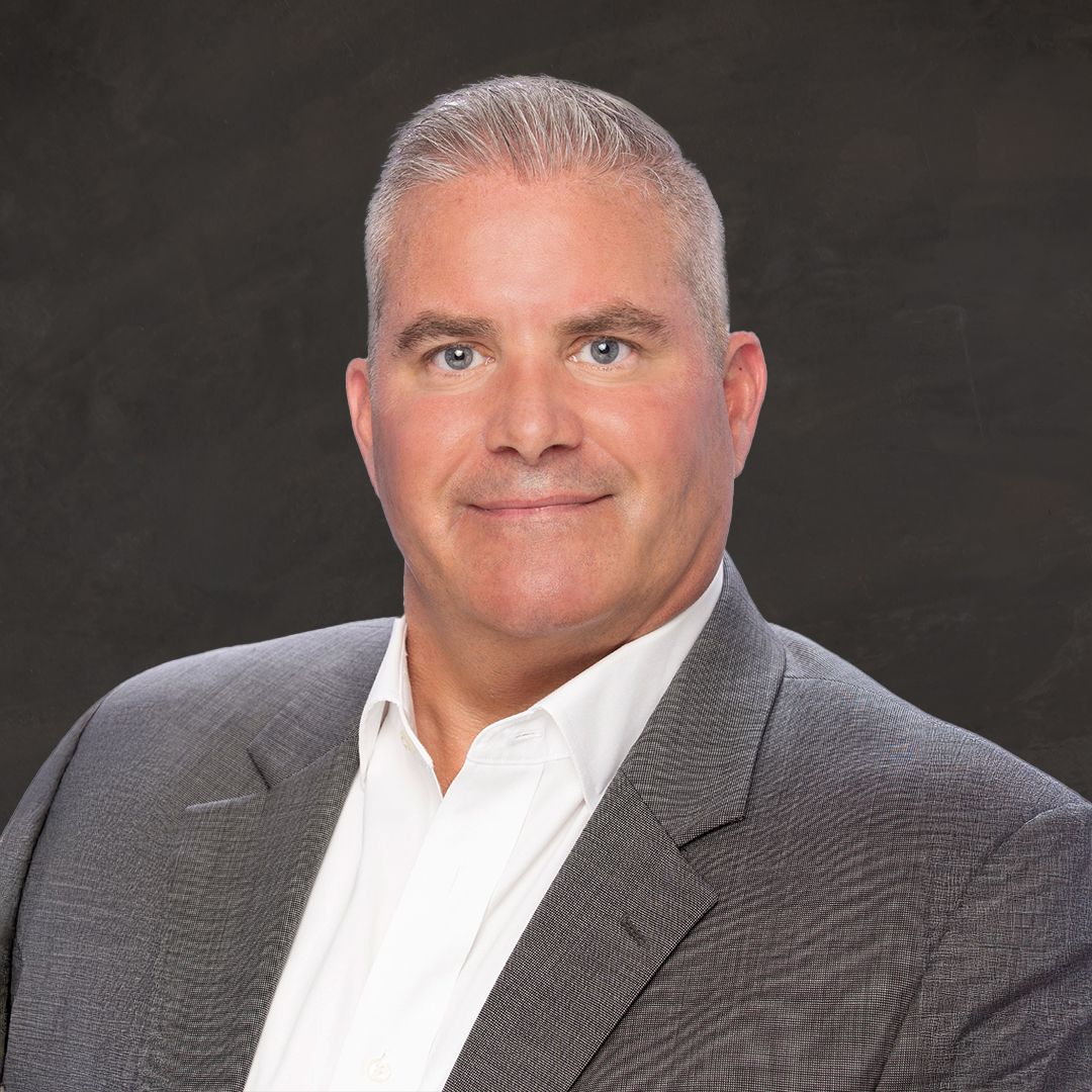 A man in a suit and tie is smiling for the camera.