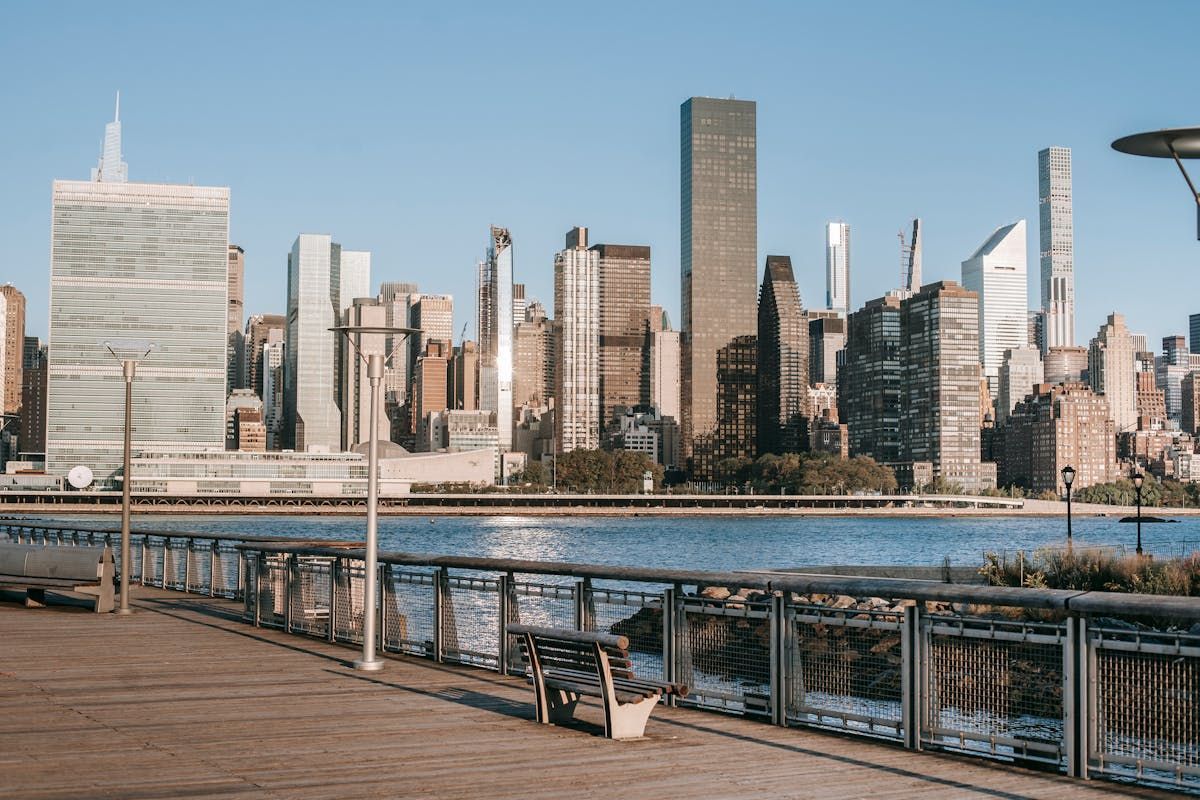 A bench is sitting on a pier overlooking a city skyline.