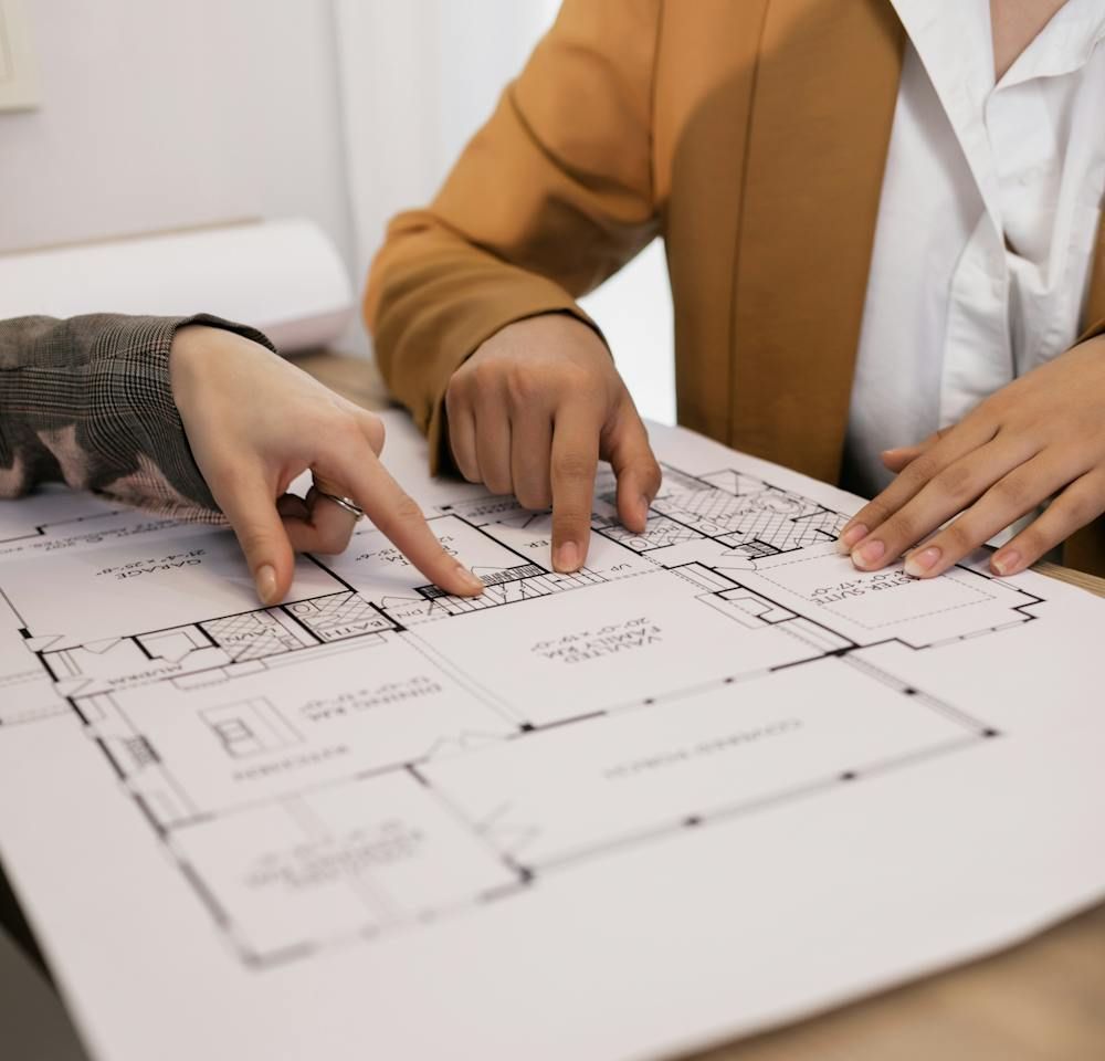 Two people are looking at a floor plan of a house