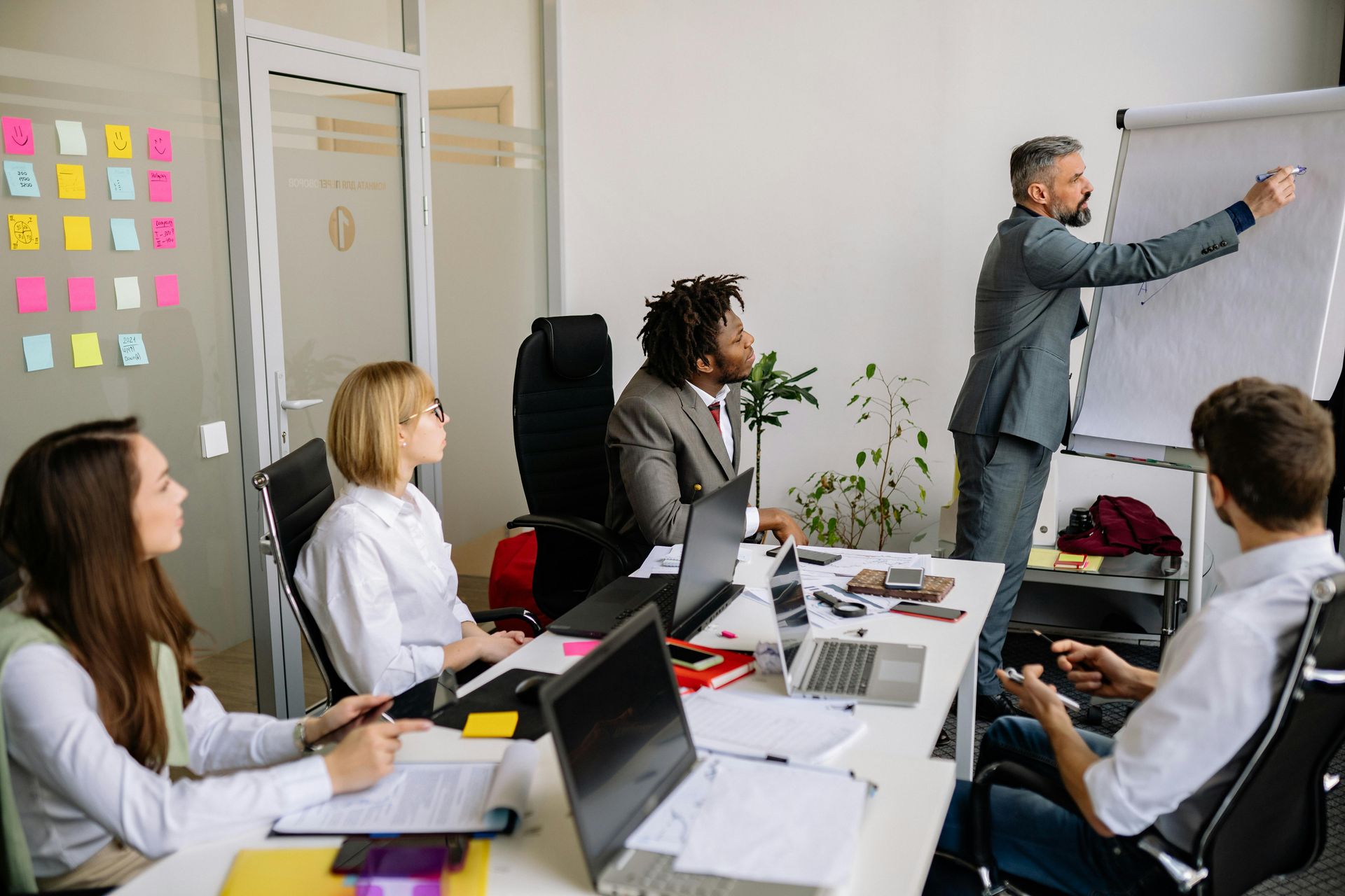 A man is giving a presentation to a group of people in an office.