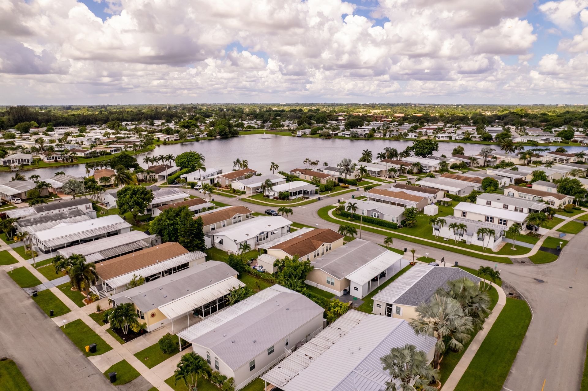 An aerial view of a mobile home park with a lake in the background.