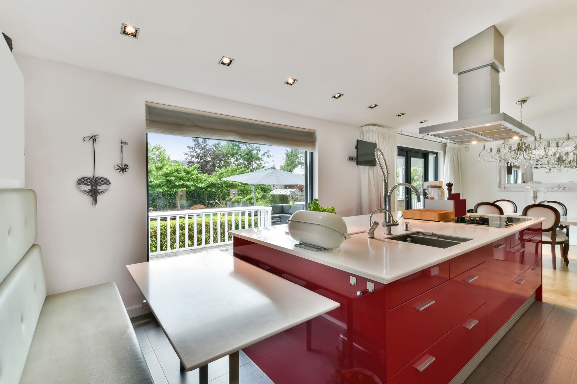 A kitchen with red cabinets and a white table