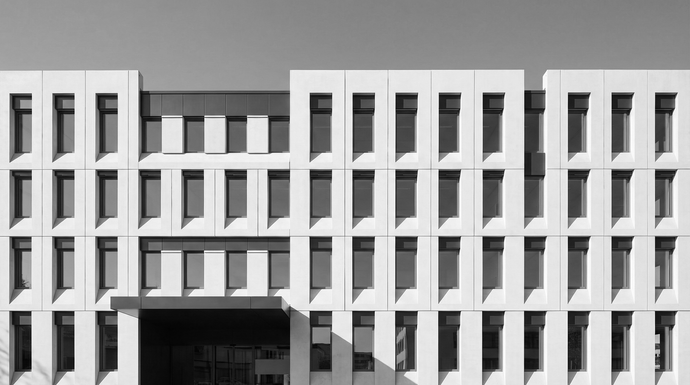 Black-and-white view of a modern geometric building facade with a central entrance.