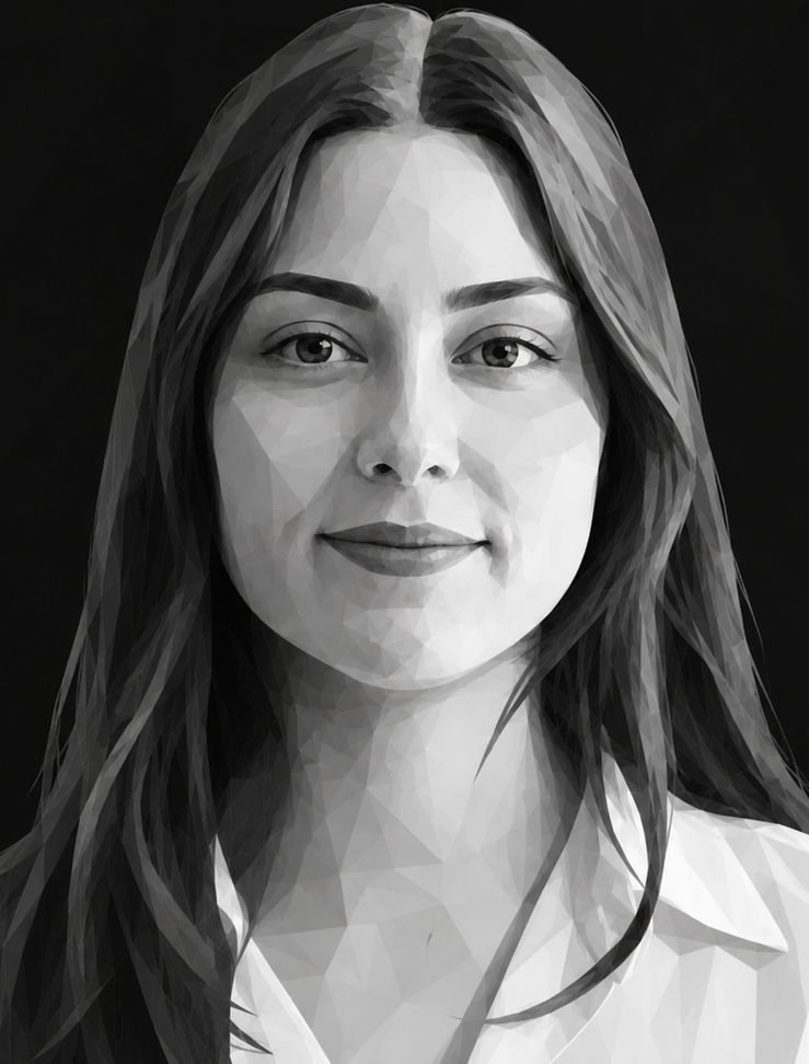 Femme aux longs cheveux bruns, rouge à lèvres rouge, souriante, vêtue d'une chemise blanche ; sur un fond flou.