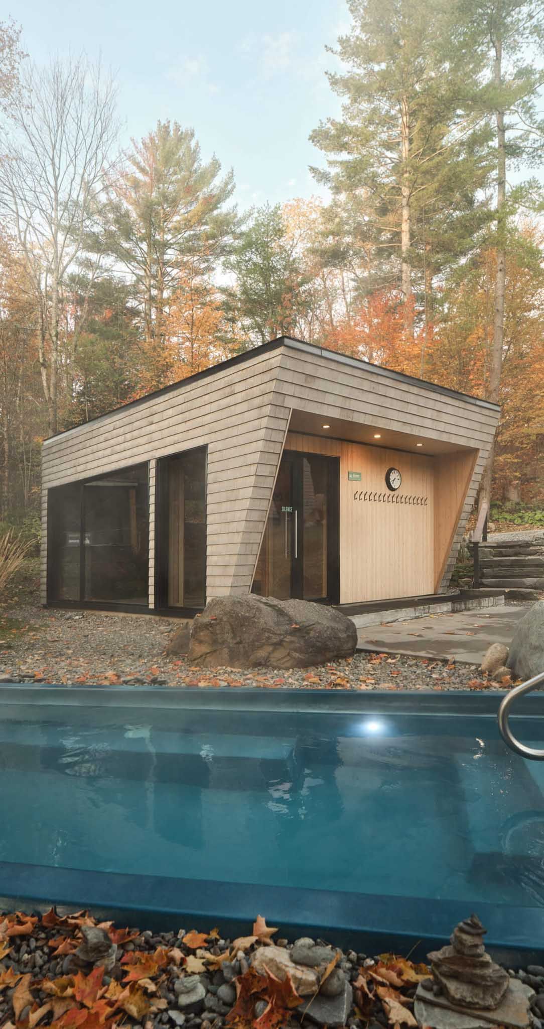 Chalet moderne avec piscine entour&eacute;e de feuillages d'automne.
