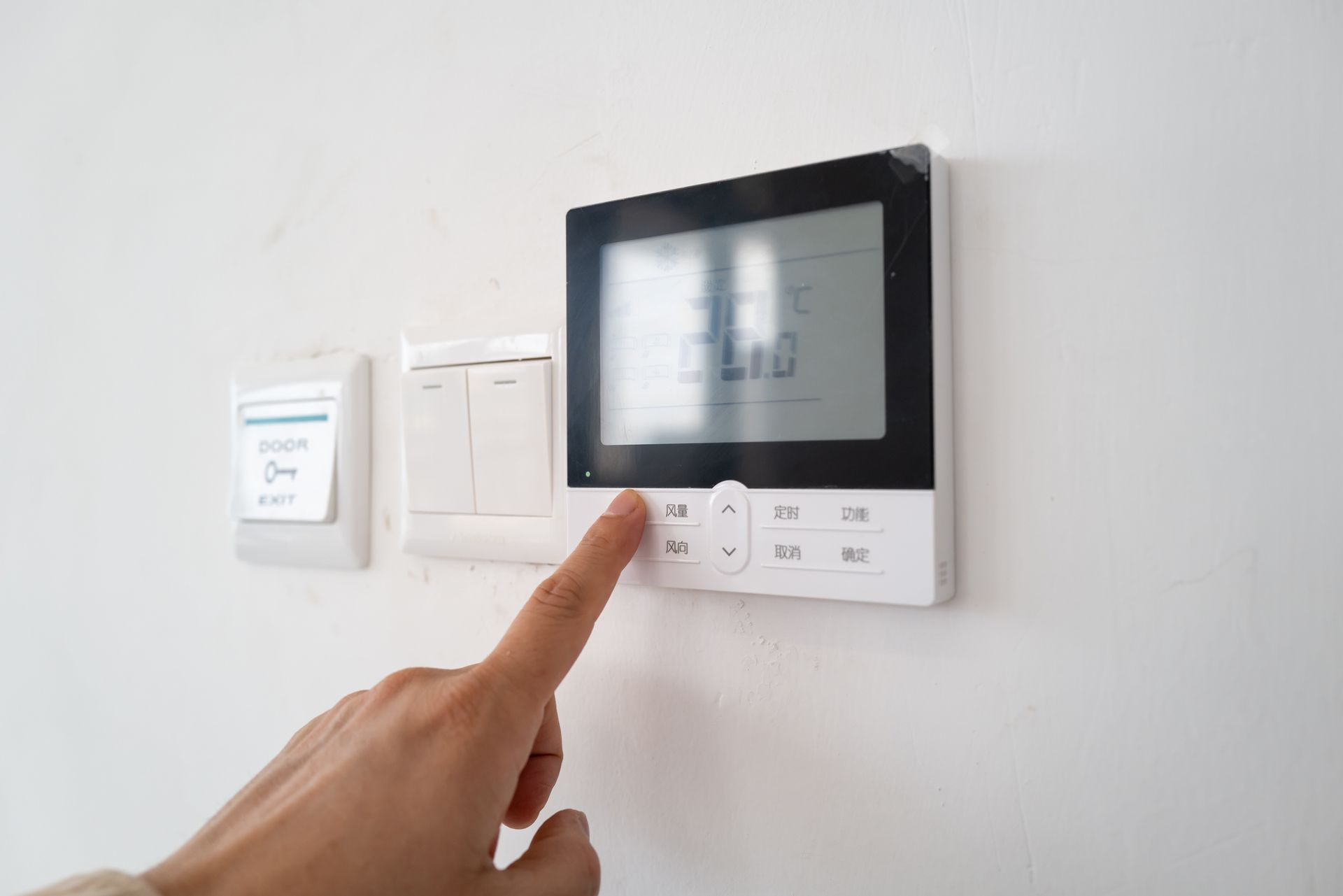 Hand Presses a Button on A White Digital Thermostat — Breezy Point, MN — JM Heating & Air