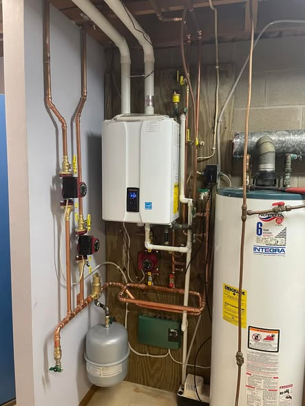 Gray furnace in a basement with silver ductwork and white pipes. Gray furnace in a basement with silver ductwork and white pipes.