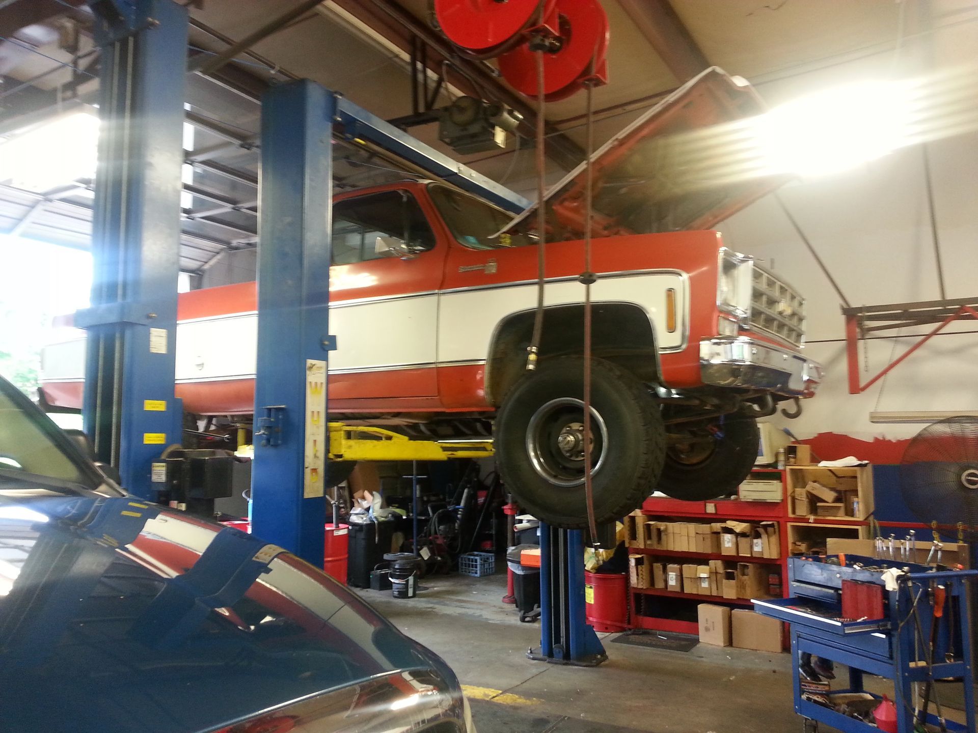 Red and white 1978 Chevy 4x4 on the lift | Bill's Auto Clinic, Inc.