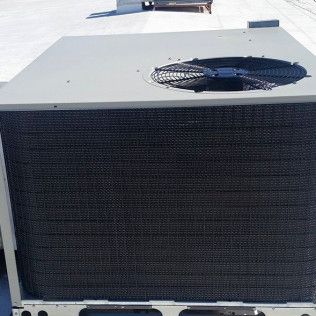 Large outdoor HVAC unit with a black grille and top-mounted fan on a rooftop.