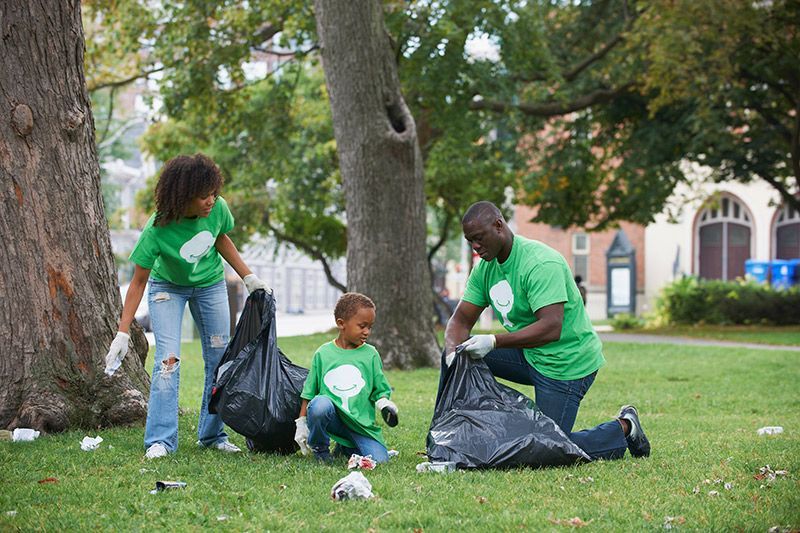 A family is picking up trash in a park.