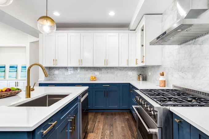 a kitchen with blue cabinets and white counter tops