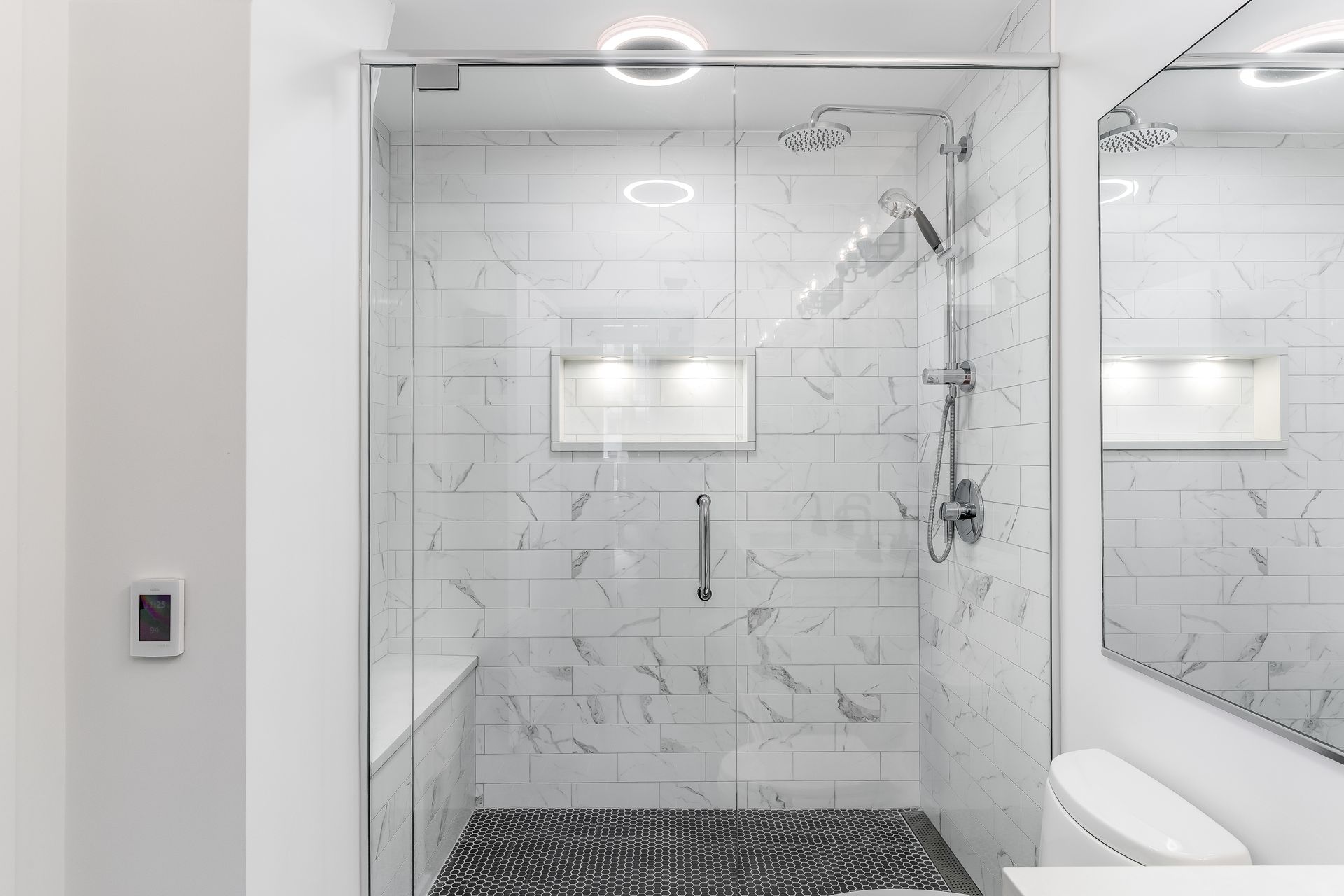A bathroom with a walk in shower and a toilet.
