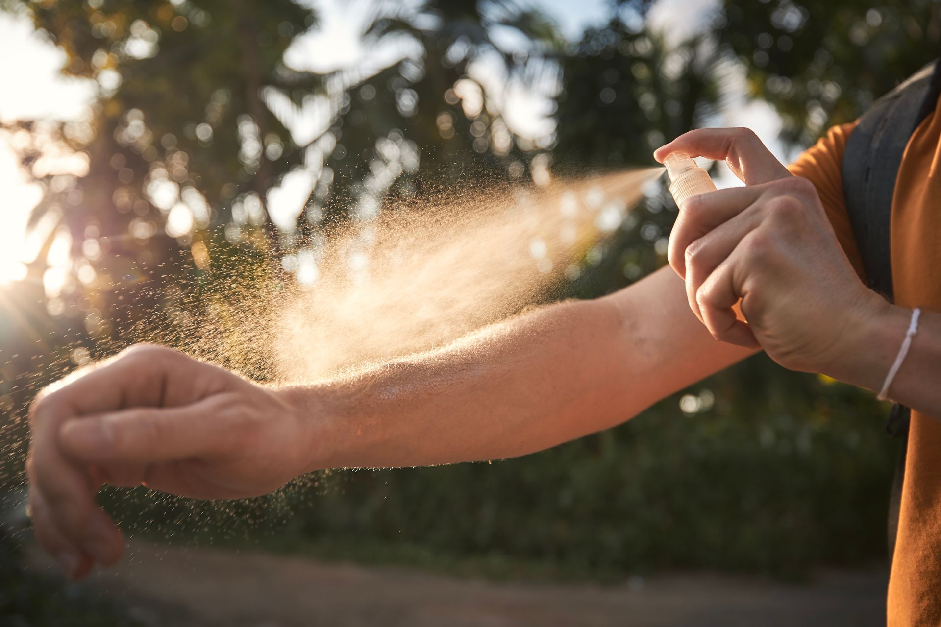 Person spraying for mosquitoes on their body - a common warm weather  pest in the coastal North Carolina and Virginia