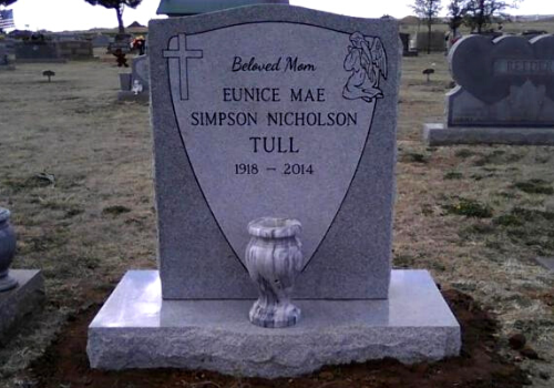 Gravestone for Eunice Mae Simpson Nicholson Tull with cross and angel engraving in a cemetery
