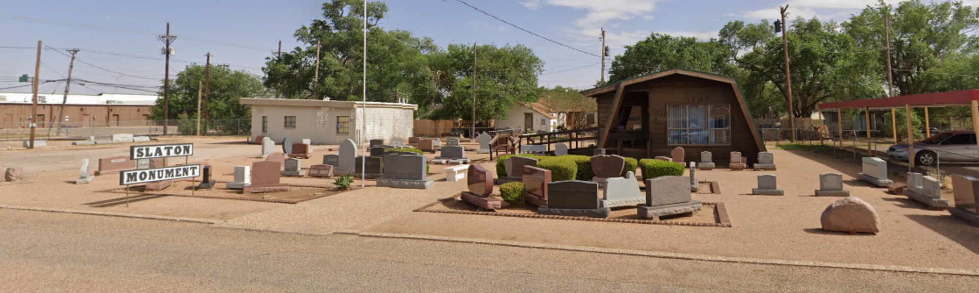 Outside of Slaton Monument business front with example headstones sitting all around.