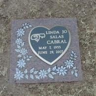 Gray memorial plaque with white flowers, inscribed “Linda Jo Salas Cabral, May 7, 1935–June 29, 2007.”
