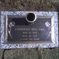 Gravestone plaque with vase, engraved “Catherine Hill Igel,” on grass outdoors