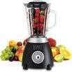 A blender filled with fruit is sitting on top of a pile of fruit.