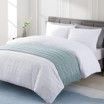 A bed with a white comforter and pillows in a bedroom.