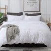 A bed with a white comforter and pillows in a bedroom.
