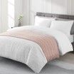 A bed with a white comforter and pillows in a bedroom.