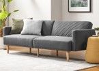 A grey couch is sitting in a living room next to a yellow ottoman.
