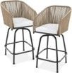 A pair of wicker bar stools with white cushions on a white background.