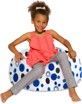 A little girl is sitting on a polka dot bean bag chair.
