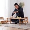 A man is sitting at a table in a living room.