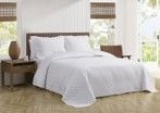 A bed with a white comforter and pillows in a bedroom.