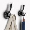A pair of hooks with a towel and umbrella hanging on them.