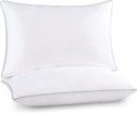 Two white pillows are sitting on top of each other on a white surface.