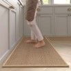 A person is walking on a rug in a kitchen.